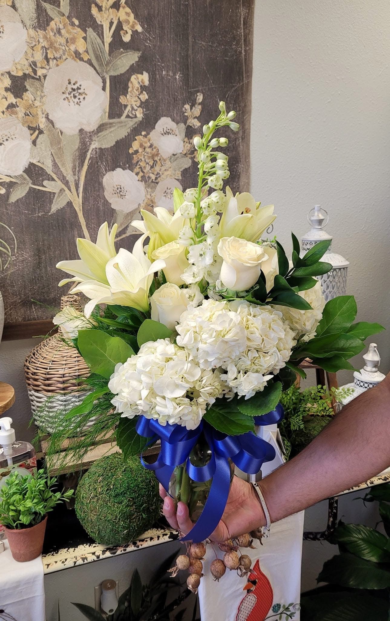 White and pink sympathy arrangement with a blue ribbon